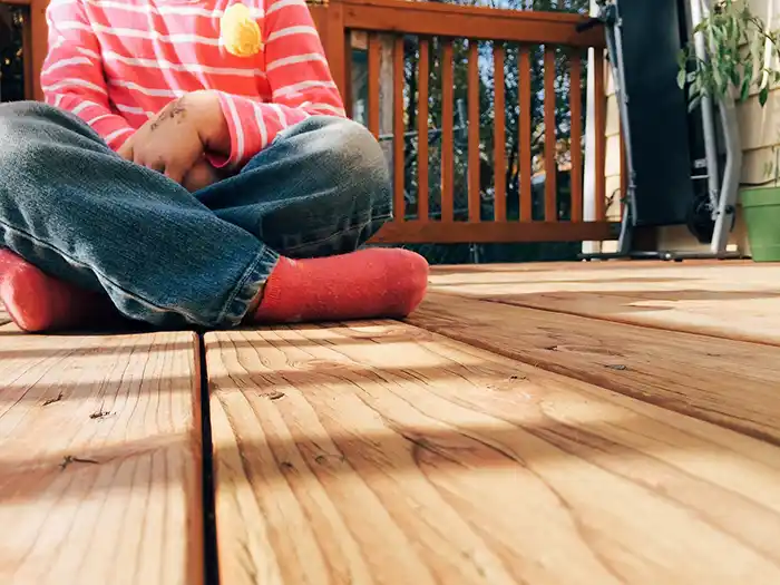 Child sitting on a new deck installation